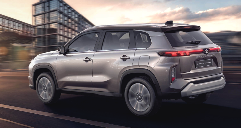 A silver 2024 Suzuki Grand Vitara speeds along a highway